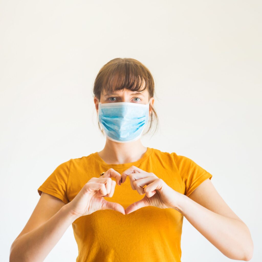 Employee wearing mask with heart hands