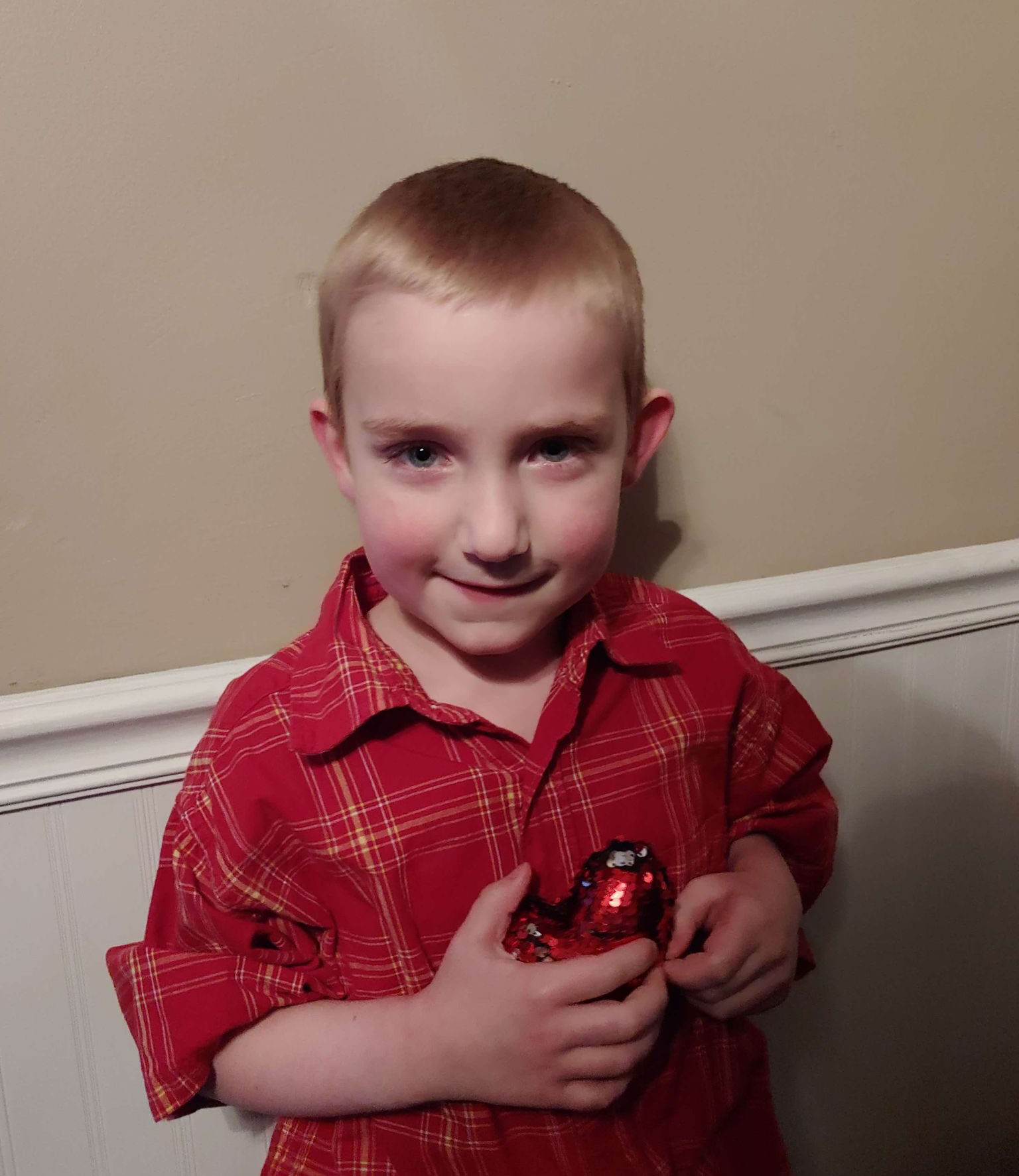 Kyler, a six-year-old Accra client, holding a balloon heart