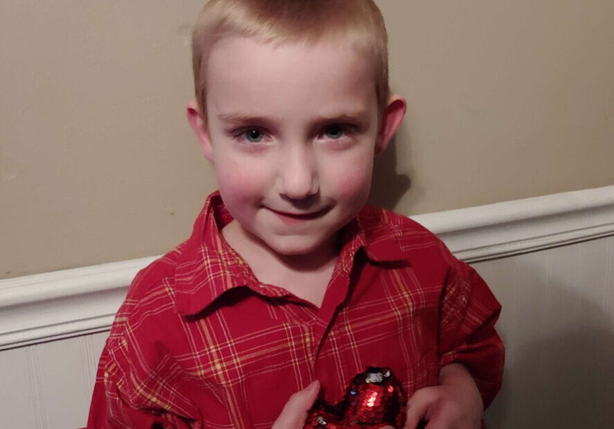 Kyler, a six-year-old Accra client, holding a balloon heart