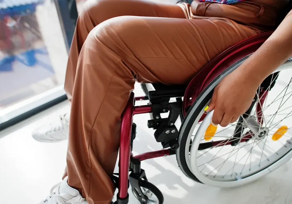 Woman sitting in a wheelchair in front of a window