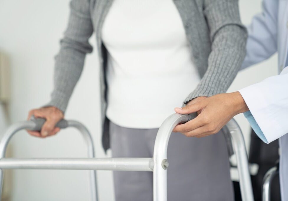 Close-up of disabled person walking with assistance