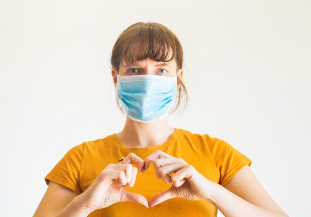 Employee wearing mask with heart hands