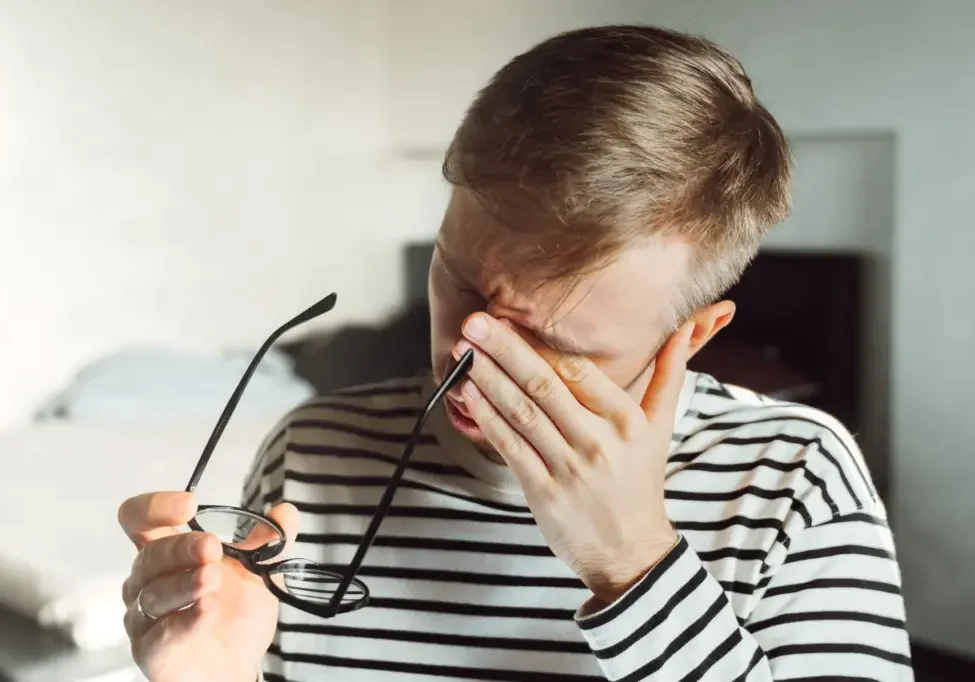 Exhausted caregiver rubbing his eyes, needing respite care